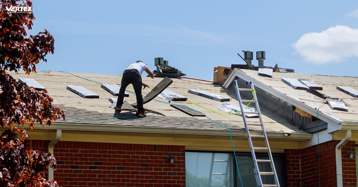 A worker stands on the roof of a brick building in Salt Lake City, installing shingles and visible roofing materials—ideal for quick response emergency roof leak repair.